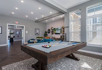 A pool table in a room with a view of the city.